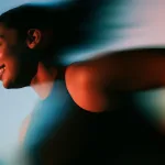 Woman smiling mid-stride, blurred with movement