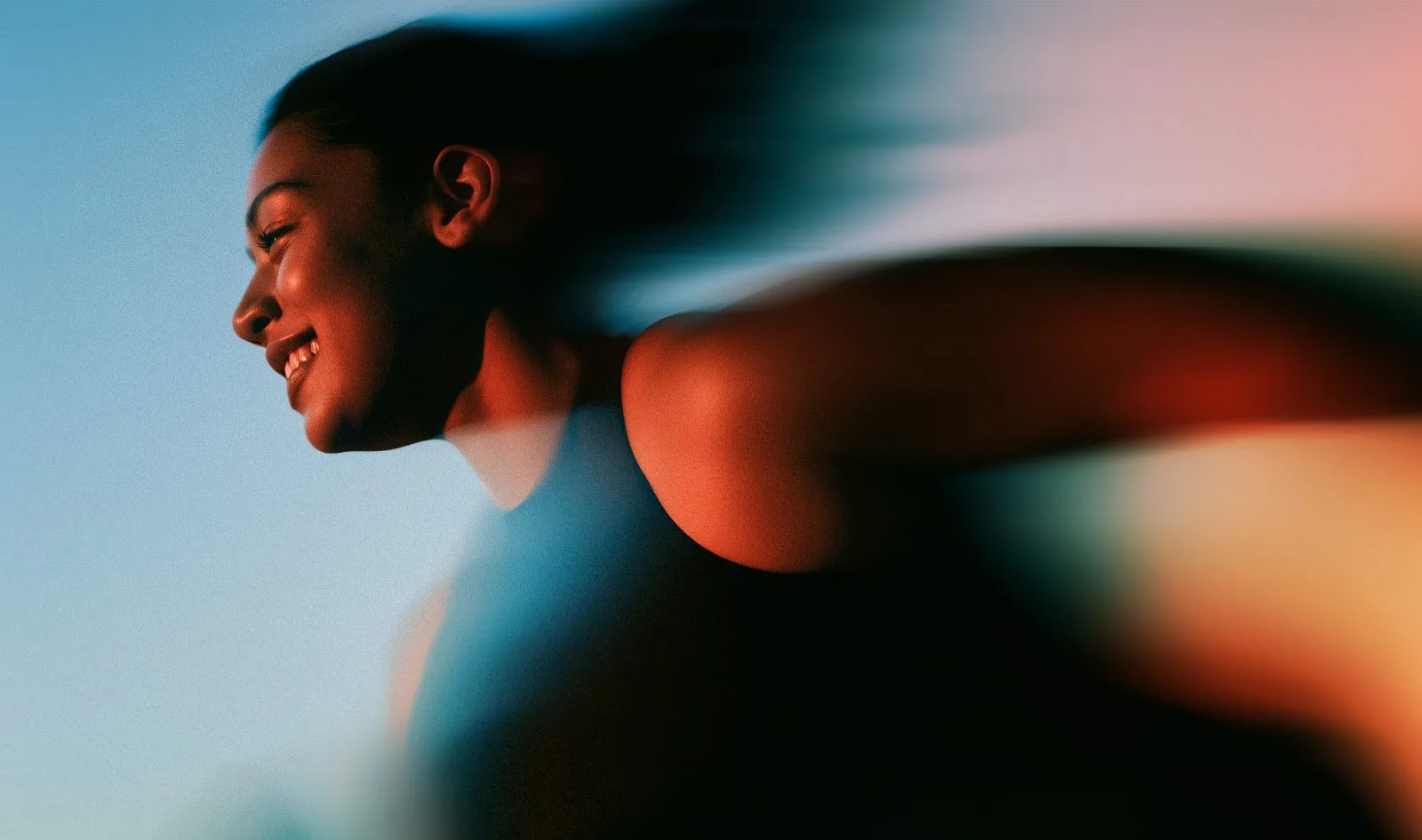 Woman smiling mid-stride, blurred with movement